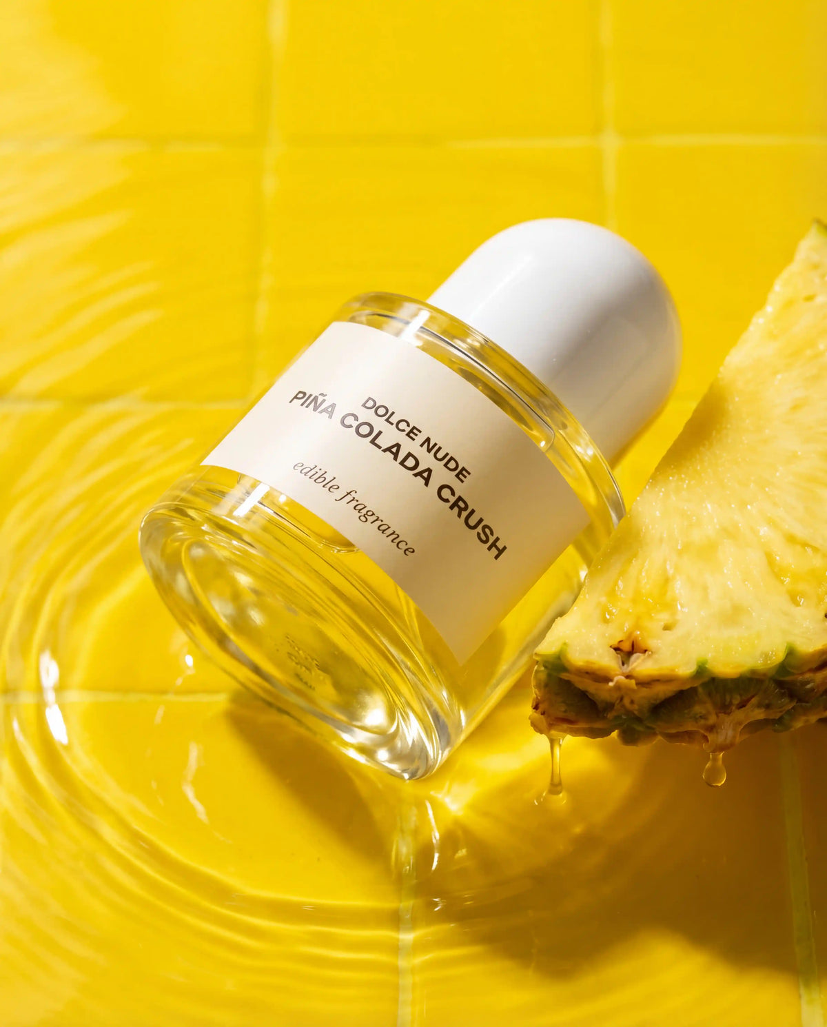 DOLCE NUDE Piña Colada Crush edible fragrance with golden pineapple swirls and tropical liquid splashes